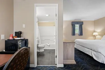 a hotel room with a bed and a bathroom at Glenwood Inn & Suites in Trail