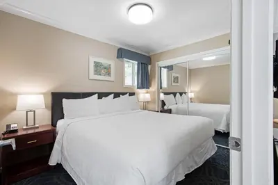 a hotel room with two beds and a mirror at Glenwood Inn & Suites in Trail