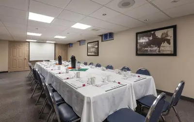 a conference room with a long table and chairs at Grama's Inn in Prince George