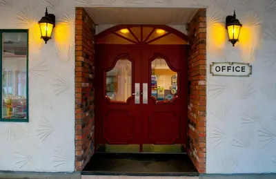 a red door with a coffee sign on a building at Grama's Inn in Prince George