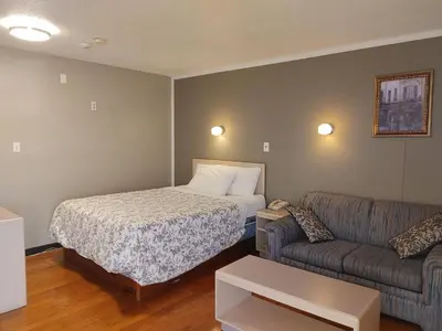 a hotel room with a bed and a couch at Magnuson Hotel Creston in Creston
