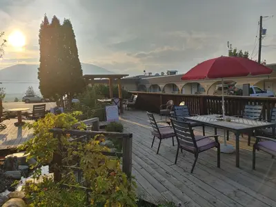 a deck with a table and chairs and an umbrella at Magnuson Hotel Creston in Creston