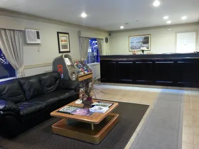 a living room with a black leather couch and a table at Heritage Inn in Hope