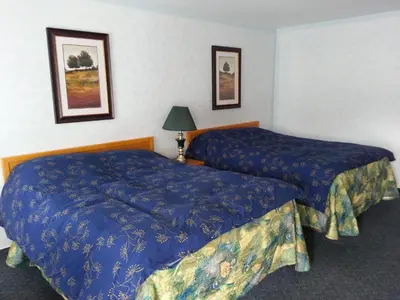 a hotel room with two beds and a lamp at Heritage Inn in Hope