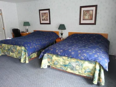 a hotel room with two beds and two lamps at Heritage Inn in Hope