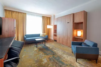a living room with two blue chairs and a couch at Hyatt Regency Calgary in Calgary