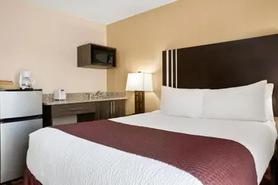 a hotel room with a large bed and a desk at Days Inn by Wyndham Sylvan Lake in Sylvan Lake