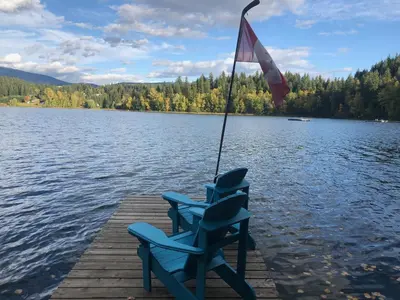 a blue chair sitting on a dock on a lake at Jasper Way Inn Resort & Campground in Clearwater