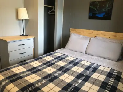 a bedroom with a bed and a dresser and a lamp at Jasper Way Inn Resort & Campground in Clearwater