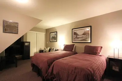 a bedroom with two beds with red comforter at Sunpath Condos by Whistler Retreats in Whistler