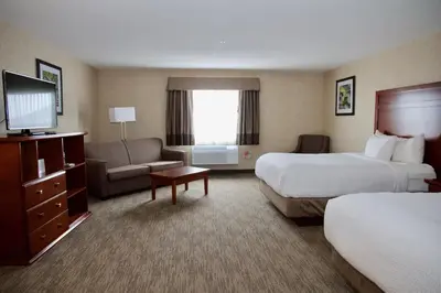 a hotel room with two beds and a television at Days Inn & Suites by Wyndham Brooks in Brooks