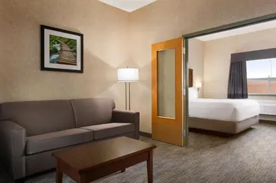 a hotel room with a couch and a bed at Days Inn & Suites by Wyndham Brooks in Brooks