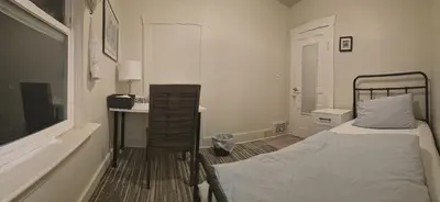 a bedroom with a bed and a table and a window at John's House in Vancouver West in Vancouver