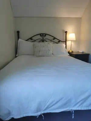 a large bed with white sheets and pillows at John's House in Vancouver West in Vancouver