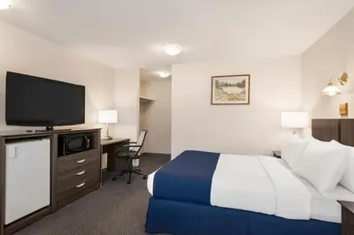 a hotel room with a bed and a flat screen tv at Travelodge by Wyndham McBride in McBride