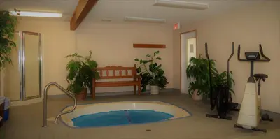 a room with a tub with plants and a bench at Travelodge by Wyndham McBride in McBride