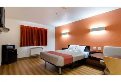 a hotel room with a bed and a table in it at Motel 6 Kerrobert, SK in Kerrobert