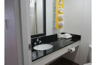 a bathroom with a sink and a mirror at Motel 6 Kerrobert, SK in Kerrobert