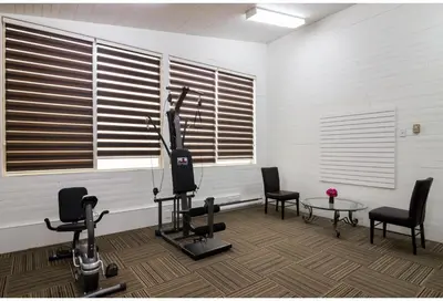 a room with a gym with chairs and a table at Motel 6 Kerrobert, SK in Kerrobert
