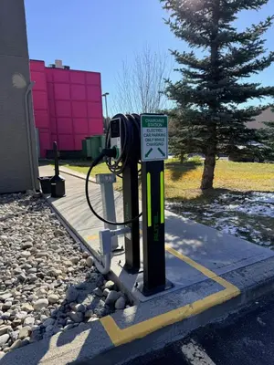 a gas pump with a sign next to a building at Velora Hinton, an Ascend Collection Hotel in Hinton