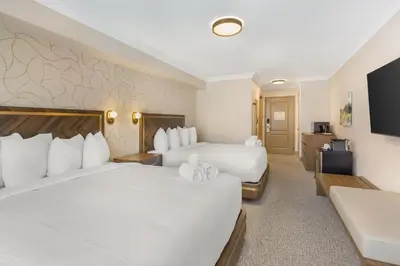 a hotel room with two beds and a flat screen tv at Velora Hinton, an Ascend Collection Hotel in Hinton