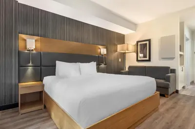 a bedroom with a large white bed and a chair at Executive Residency by Best Western Calgary City View North in Calgary