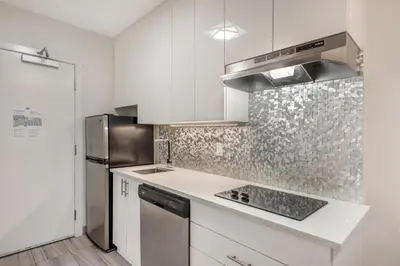 a kitchen with white cabinets and a stainless steel refrigerator at Executive Residency by Best Western Calgary City View North in Calgary