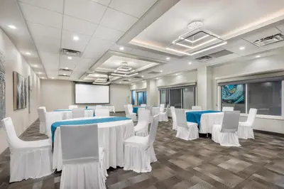 a conference room with white tables and chairs and a screen at Executive Residency by Best Western Calgary City View North in Calgary