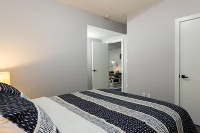 a bedroom with a bed with a black and white comforter at Modern Executive Suite I Complimentary Netflix & Parking! in Edmonton