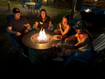 a group of people sitting around a fire pit at The Tide's Inn in Parksville