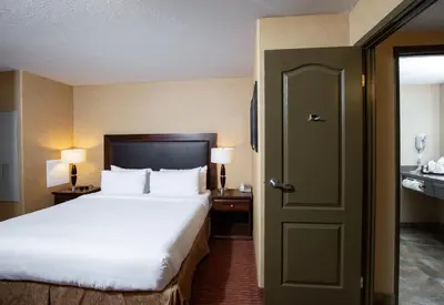 a hotel room with a bed and a door at Pomeroy Hotel Fort St. John in Fort Saint John
