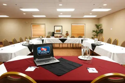 a conference room with a laptop on a table at Pomeroy Inn and Suites Chetwynd in Chetwynd