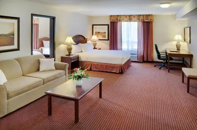 a hotel room with a bed and a couch at Pomeroy Inn & Suites Fort St. John in Fort Saint John