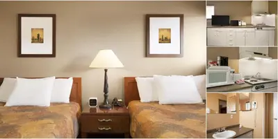 a hotel room with two beds with white pillows at Central Suite Hotel in Lloydminster