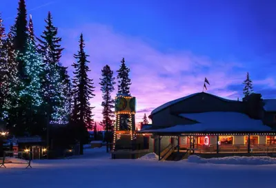 a building with christmas lights in the snow at night at The Bulldog Hotel in Silver Star