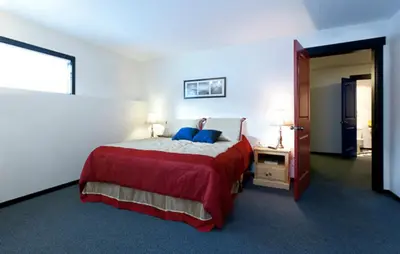 a bedroom with a large bed with a red blanket at The Bulldog Hotel in Silver Star