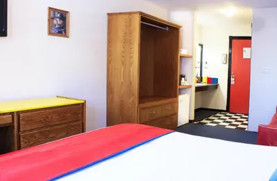 a bedroom with a bed and a desk and a cabinet at The Bulldog Hotel in Silver Star