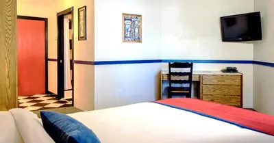 a bedroom with a bed and a desk and a television at The Bulldog Hotel in Silver Star