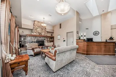 a living room with a couch and a fireplace at Stony Plain Inn & Suites in Stony Plain