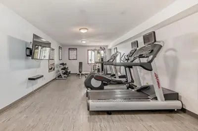 a fitness room with a treadmill and a gym at Stony Plain Inn & Suites in Stony Plain