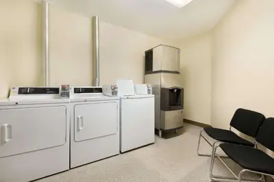 a kitchen with white appliances and a refrigerator at Ramada by Wyndham Nanaimo in Nanaimo
