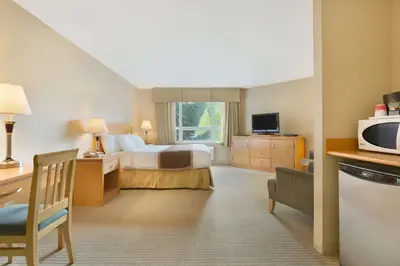 a hotel room with a bed and a microwave at Ramada by Wyndham Nanaimo in Nanaimo