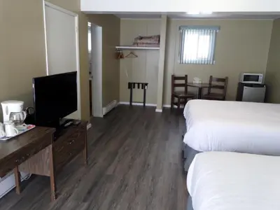 a hotel room with two beds and a flat screen tv at Ray Lyn Motel in Trail