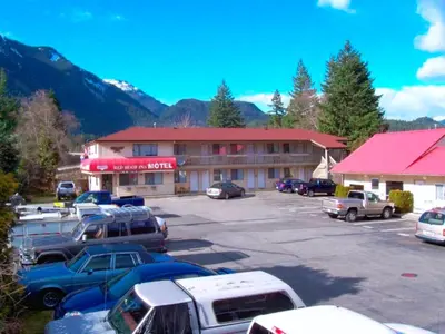 a parking lot with cars parked in front of a hotel at Red Roof Motor Inn in Hope