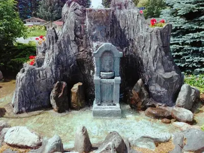 a garden with a statue in a tree stump at Red Roof Motor Inn in Hope