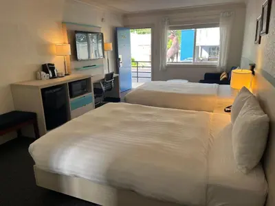 a hotel room with two beds and a kitchen at Revelstoke Lodge in Revelstoke