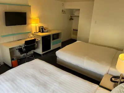 a hotel room with two beds and a desk at Revelstoke Lodge in Revelstoke