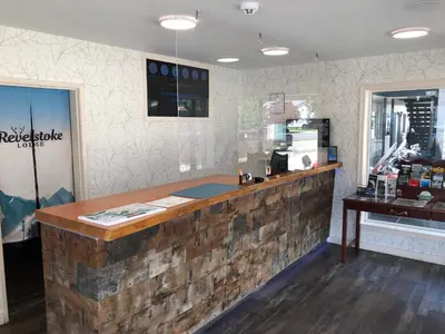 a bar in a restaurant with a wooden counter at Revelstoke Lodge in Revelstoke