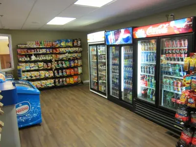 a store aisle with two refrigerators and drinks at Reynolds Hotel in Lillooet