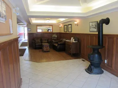 a lobby with a fireplace in the middle of a room at Reynolds Hotel in Lillooet